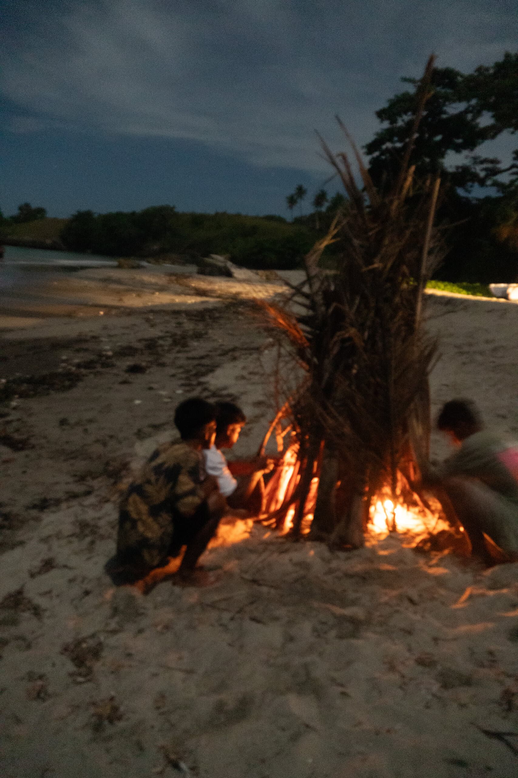 Lighting the beach bonfire as evening falls