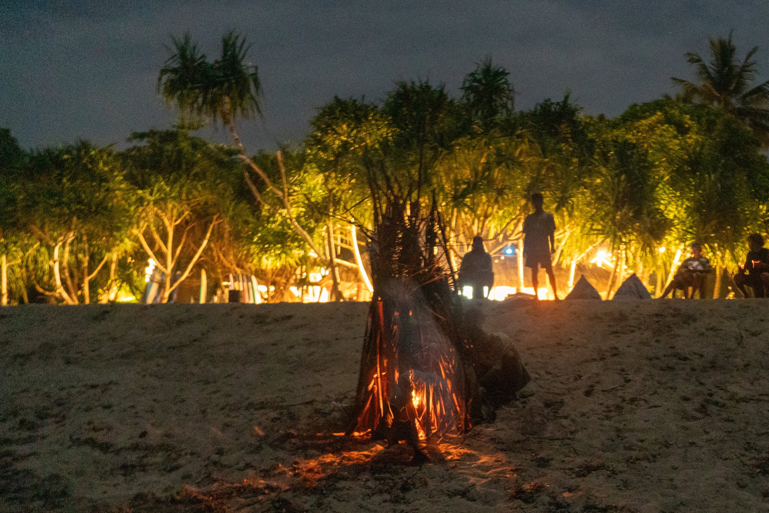 Beach bonfire being started at dusk